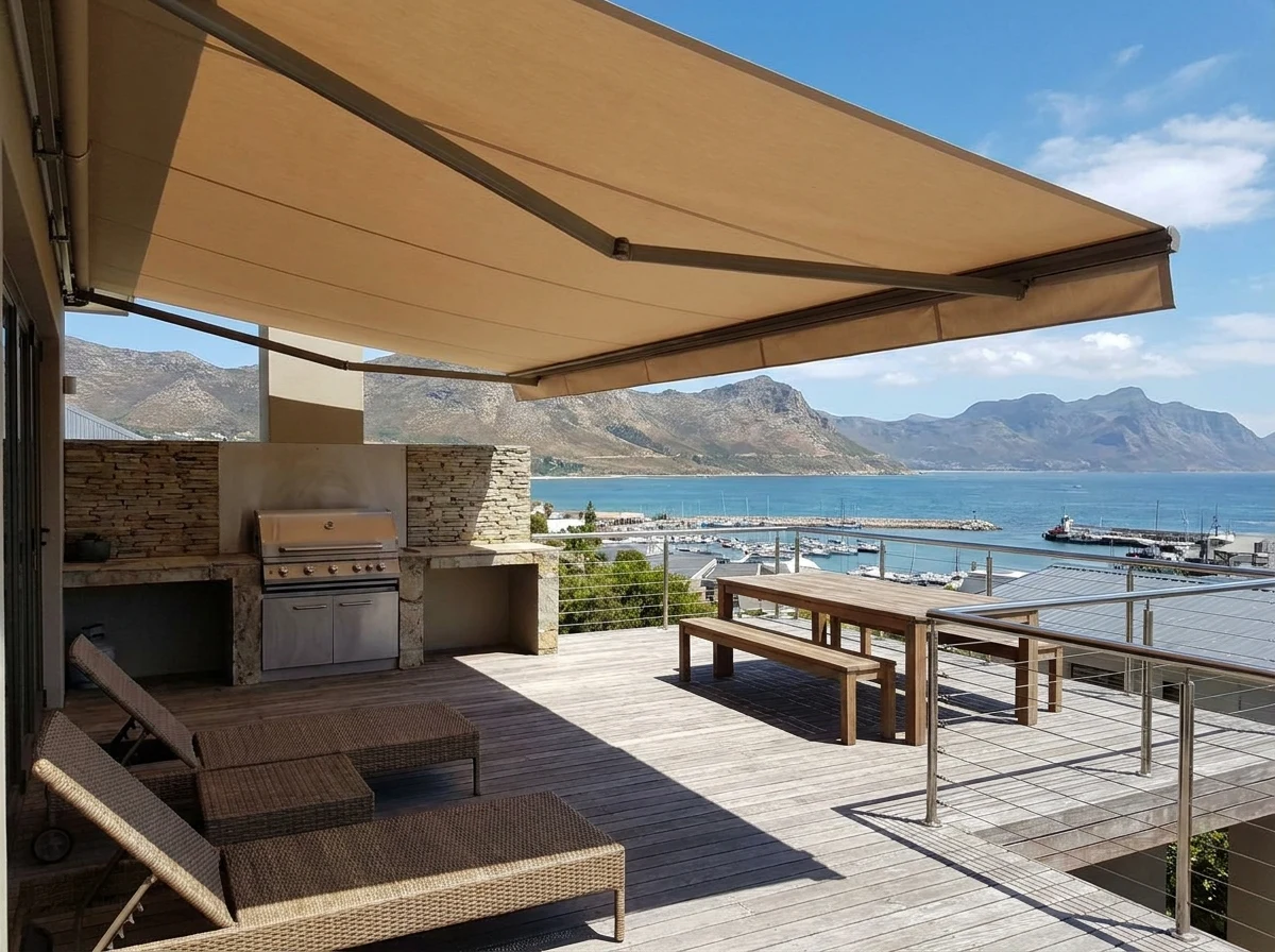 Folding-arm awning extended over a braai deck on a home above the Gordon's Bay harbour